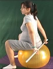 ćwiczenie rozciągające mięśnie piersiowe w ciąży na dużej piłce